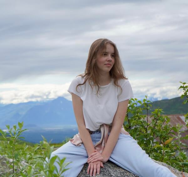 a woman sitting on a rock